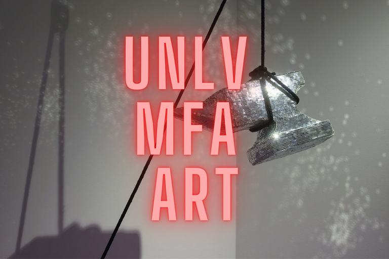 A shiny anvil hanging in an art gallery with the words &quot;UNLV MFA ART&quot;