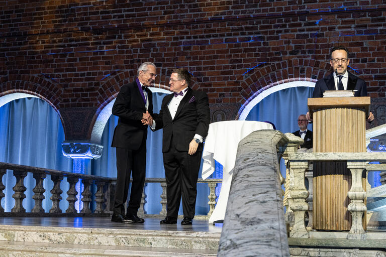 Dr. Jeffrey Cummings (left) receives his medal during the Melvin Goodes Award dinner in Stockholm