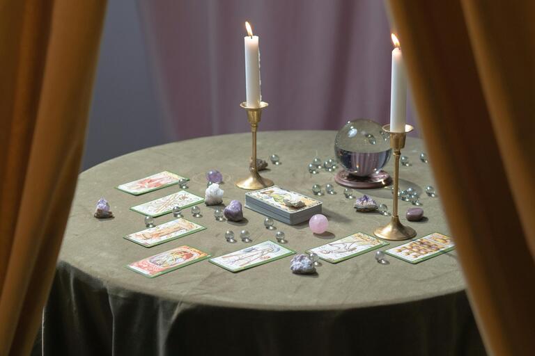 A table set for a seance with tarot cards and candles.