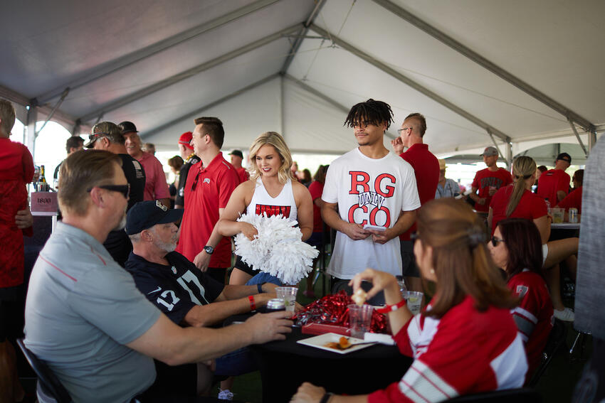 Alumni and students tailgating in a tent
