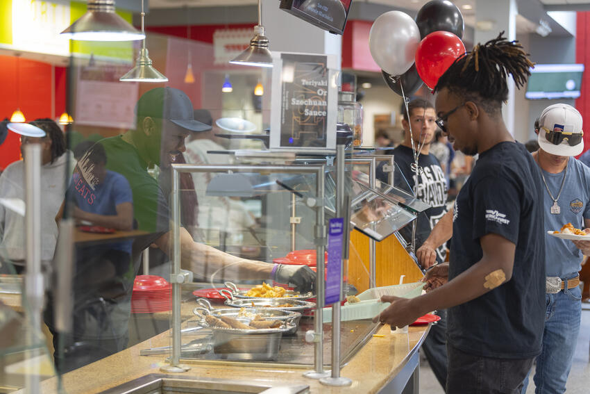 Student selecting food at the Dining Commons