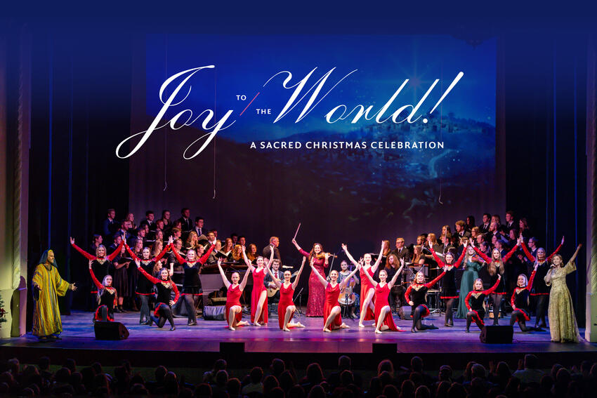 Jenny Oaks Baker is center stage, surrounded by many performers from her Christmas show. The superimposed text reads, &quot;Joy to the World! A Sacred Christmas Celebration.&quot;