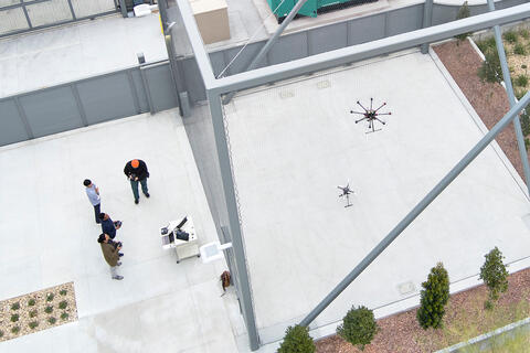 students flying a drone inside a cage