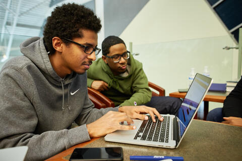 Students looking at a laptop