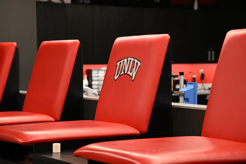 Red empty chairs with a U-N-L-V Logo