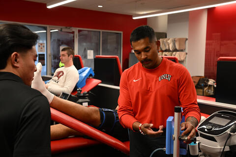 Person wearing red demonstrating how to use a medical instrument